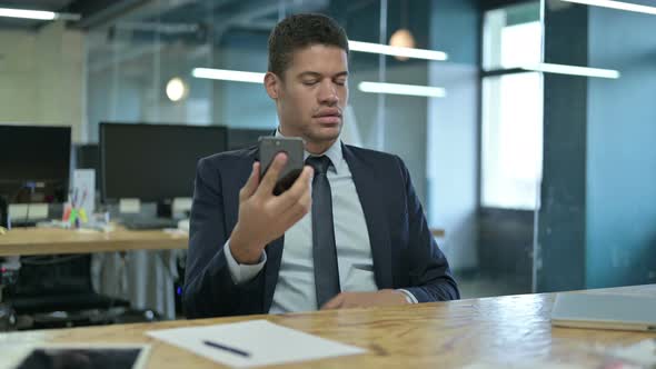 Sad African Businessman Having Loss on Smartphone