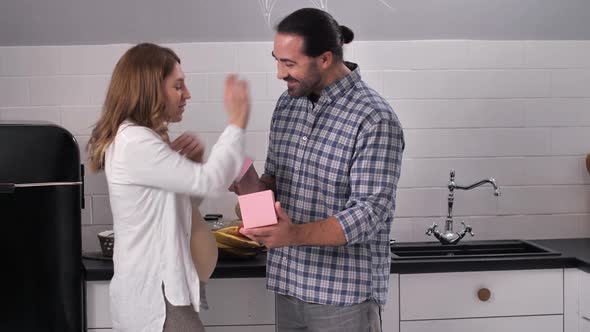 Loving Man Opening Gift Box for Pregnant Wife