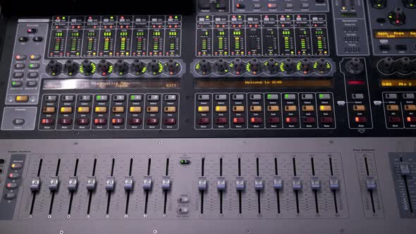 Colorful dancing indicator lights and levers on a mixing board