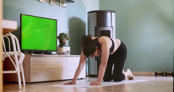 Woman Exercising at Home Following a Remote Fitness Class