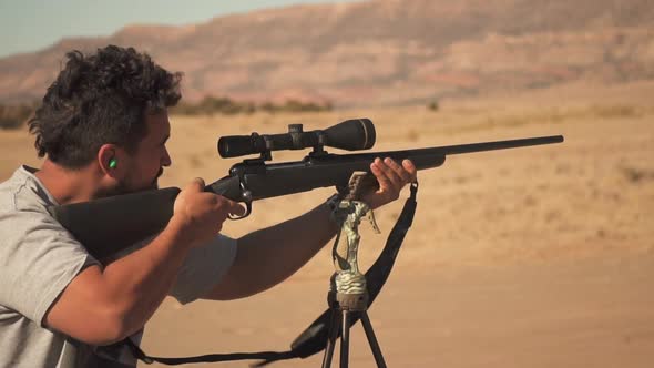 Hunter Shooting With Gun In Desert. Target Practice In Slow Motion.