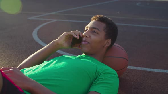 Athlete Chatting on Phone on Basketball Court