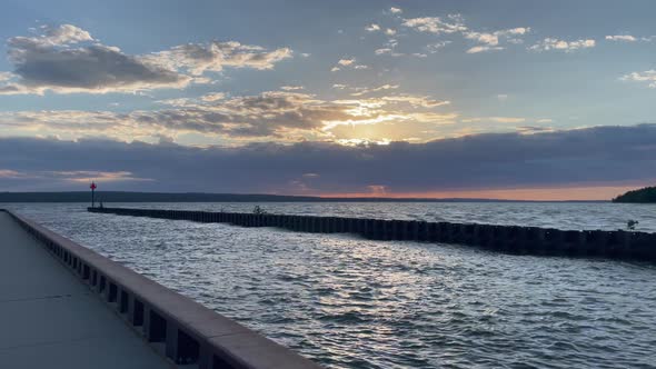 Beautiful Sunset Over Lake Orange Sun Blue Water Cloudy Evening With Light Beams on Boardwalk