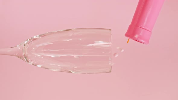 Colorful Candy Confectionery Run Poured Into a Wineglass Glass on Pink Background