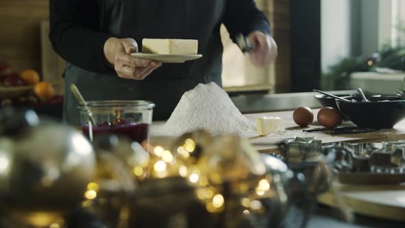 Woman in kitchen making dough for cookies