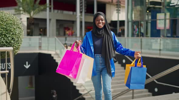 Black Woman with Paper Bags Walking After Shopping