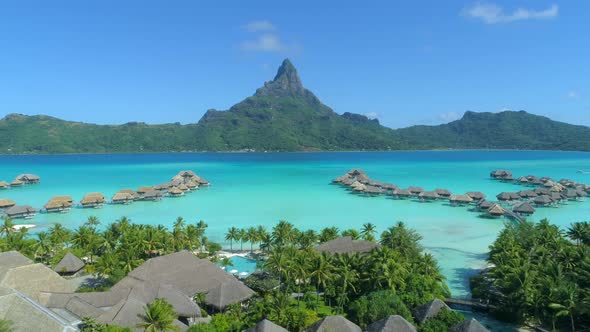 Aerial drone view of a luxury resort and overwater bungalows in Bora Bora tropical island.