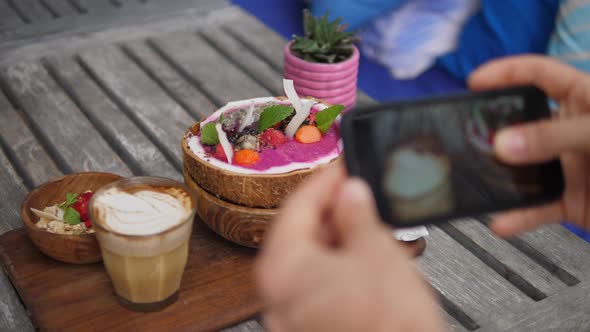 Top View of Vegan Breakfast of Smoothie Coconut Bowl Served on Wooden Board with Dairy Free Latte