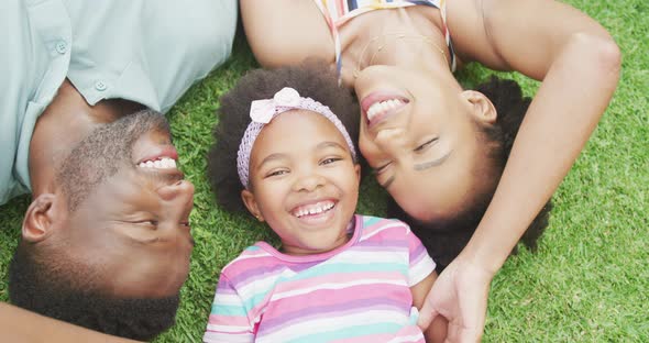 Portrait of happy african american couple with their daughter playing in garden