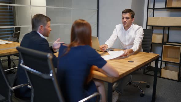 Family and Realtor Businessman in Boardroom Discussing About Mortgage Contract.