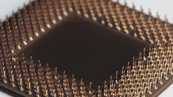 The Computer Processor CPU with Gold Plated Contacts Spins on White Background