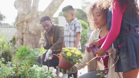 Happy african american parents with children gardening together