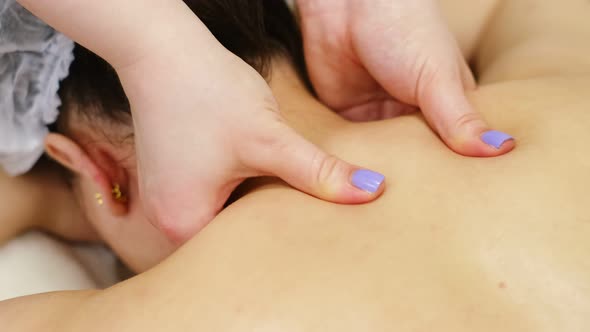 Unrecognizable Woman Masseur with Strong Hands Massage the Patient Lying on Massage Table