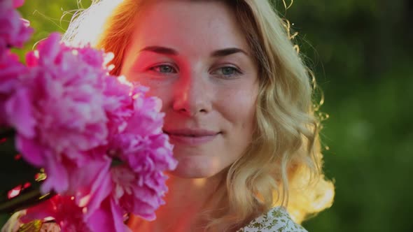 Closeup Portrait Woman with Long Hair with a Bouquet of Peonies