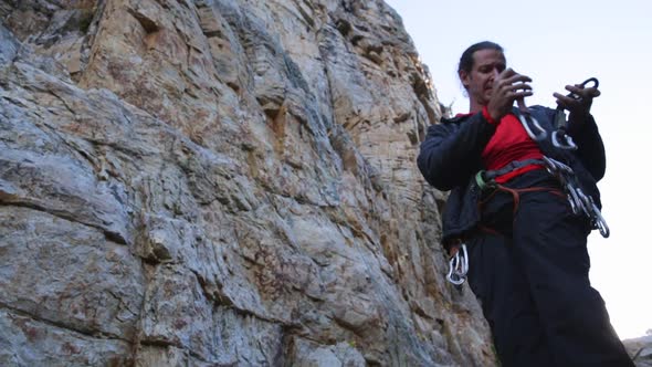 A young man preparing equipment to go rock climbing.