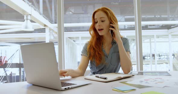 Executive talking on mobile phone while using laptop 4k