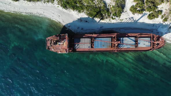 Top-down View of a Sunken Ship Aground. A Beautiful Huge Dry Cargo Ship of Red Color Has Long Been