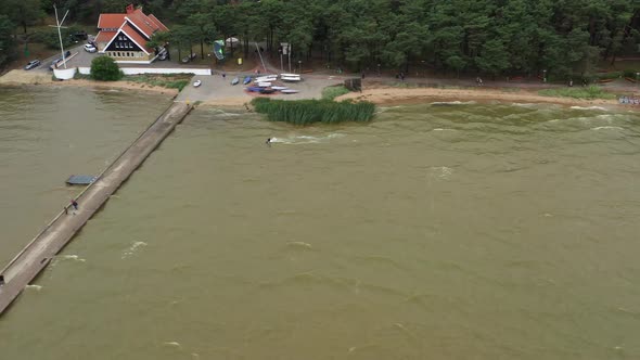 AERIAL: Surfer Jumps Over Stone Pier And Lands on the Other Side of Pier