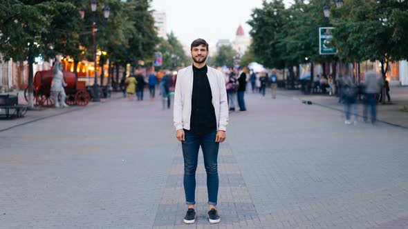 Time-lapse of Bearded Young Man Standing in the Street in Big City and Looking at Camera Then Moving