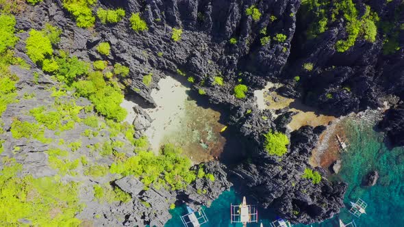 Aerial Drone View of Swimmers Inside a Tiny Hidden Tropical Lagoon Surrounded By Cliffs