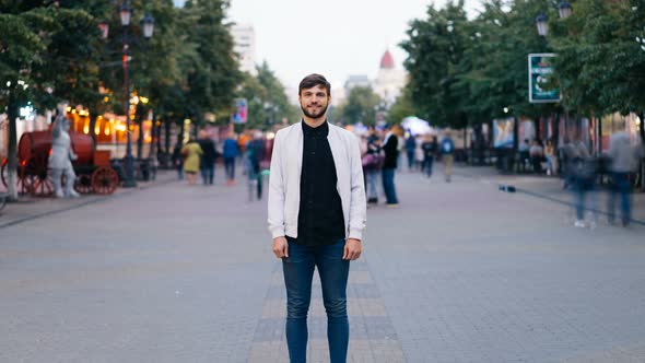 Zoom in Time-lapse of Attractive Young Guy Businessman Looking at Camera Standing in the Street in