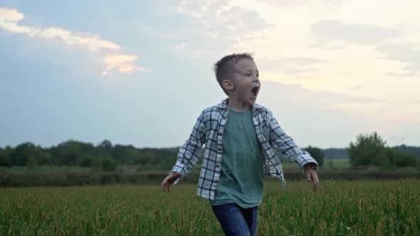 A Smiling Boy Catches and Bursts Soap Bubbles