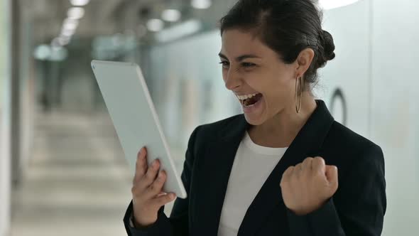 Excited Indian Businesswoman Having Success on Tablet