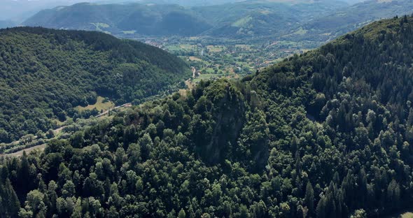 Mountain Peak With Dense Foliage In Romania On A Sunny Day. aerial drone