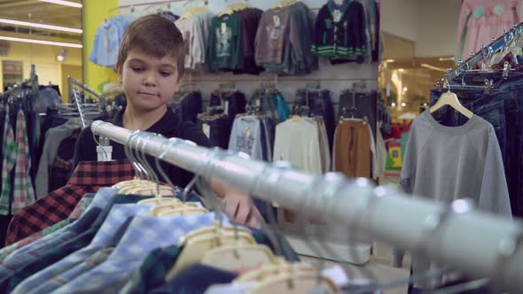 Kid Choose Garment in the Shop