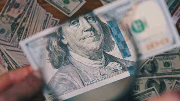 One Hundred Dollars Look Under Magnifying Glass Above Money Table