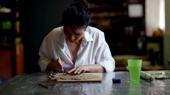 a Woman Master of Pottery Sculpts in the Workshop