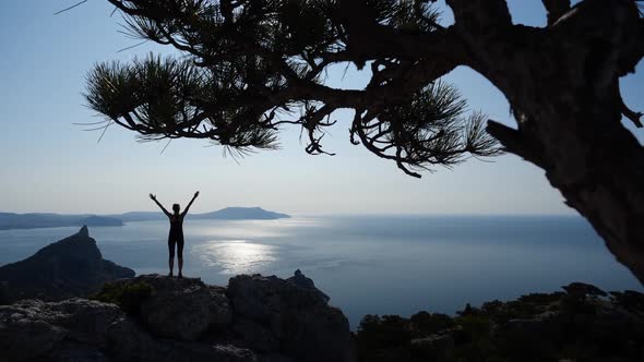 Sporty Girl Climbed To the Top of the Cliff and Enjoying the View of the Sun and Sea. Young Woman