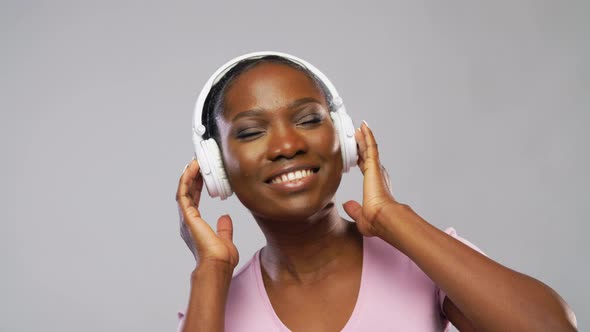 African Woman in Headphones Listening To Music