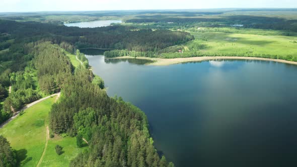 AERIAL: Flying Over Majestic Lake Over Forest on Sunny Summer Day