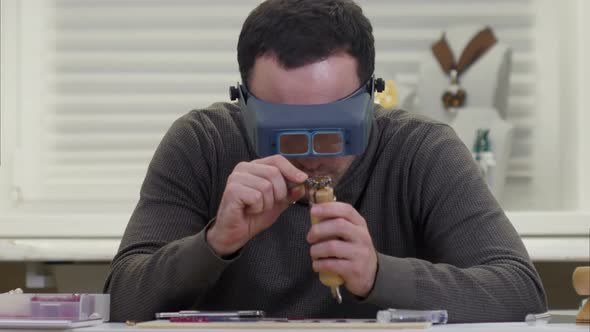 Jeweler Looking at the Dimond Ring Through Glasses in a Workshop