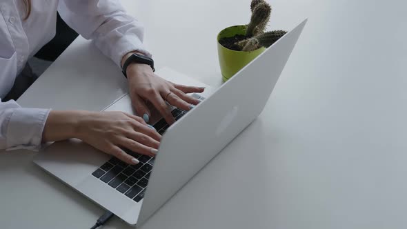 Close Up Side View of Woman's Hands Typing on a Laptop