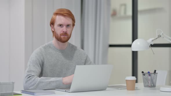 Redhead Man with Laptop Shaking Head As Yes Gesture 