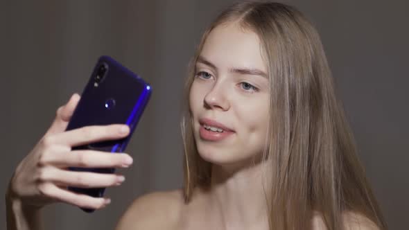 Smiling Young Woman Having Video Chat Through Phone.