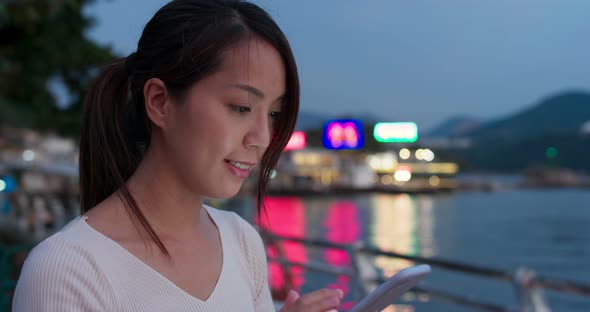 Woman check on mobile phone in city at night