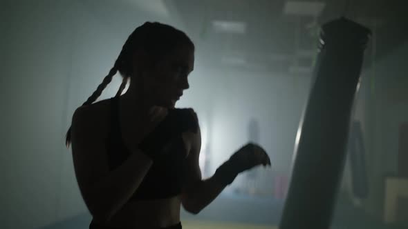 Caucasian Woman Fighter Trains His Punches and Defense in the Boxing Gym Contour Lighting Slow