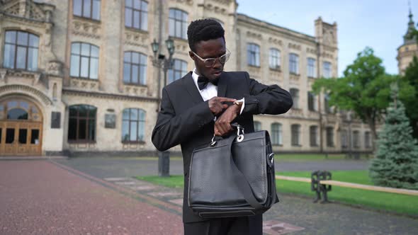 Medium Shot Portrait of Self Assured Elegant African American Man in Suit with Attache Case Standing