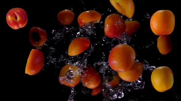 Halves of Apricot Bounce on a Black Background