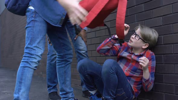 Schoolchildren Throwing Things Out of Backpack on Boy Head, Bullying at School