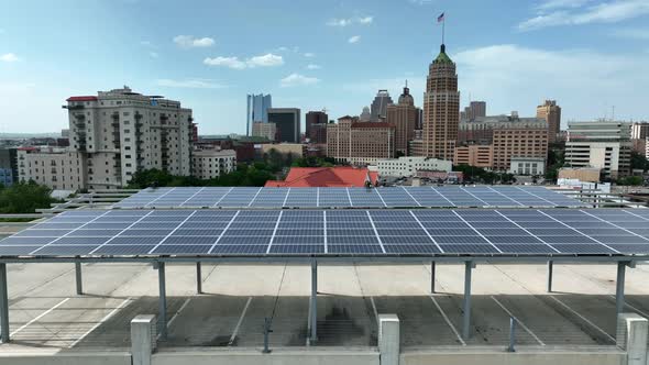 Solar panel array with urban American city skyline in distance. Aerial truck shot.