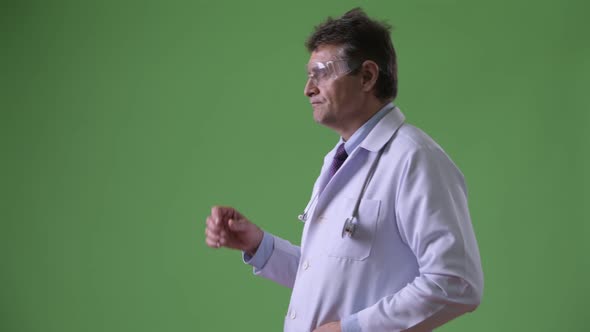 Mature Handsome Man Doctor Against Green Background