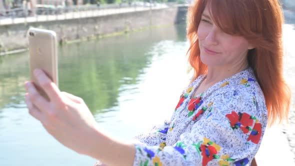 Adult woman outdoor using smart phone taking selfie