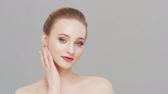 Studio portrait of young, beautiful and natural woman over grey background.