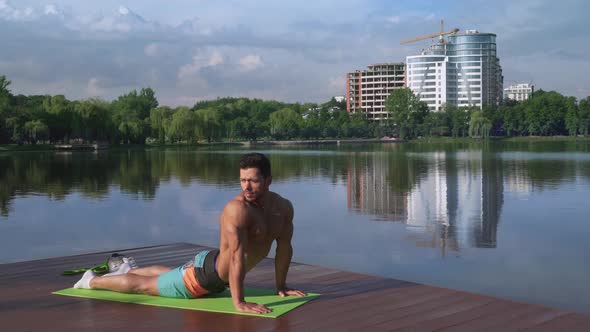 Handsome Guy with Bare Chest Stretching Body on Yoga Mat