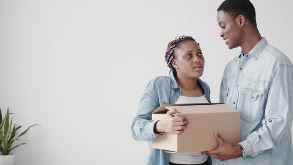 A Young African-American Couple Are Packing Boxes with Stuff