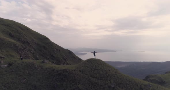 Drone fotoage of a man who rises his hands after reaching the top of Cerro Chame mountain, district